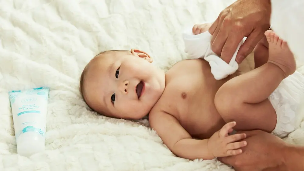 Bébé allongé lors du change, prévention des chutes de la table à langer