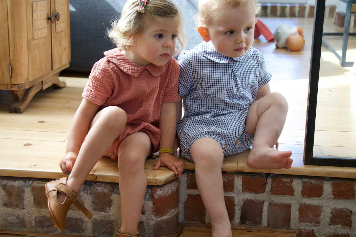 Bébé marchant sur la pointe des pieds sur un parquet, pieds nus