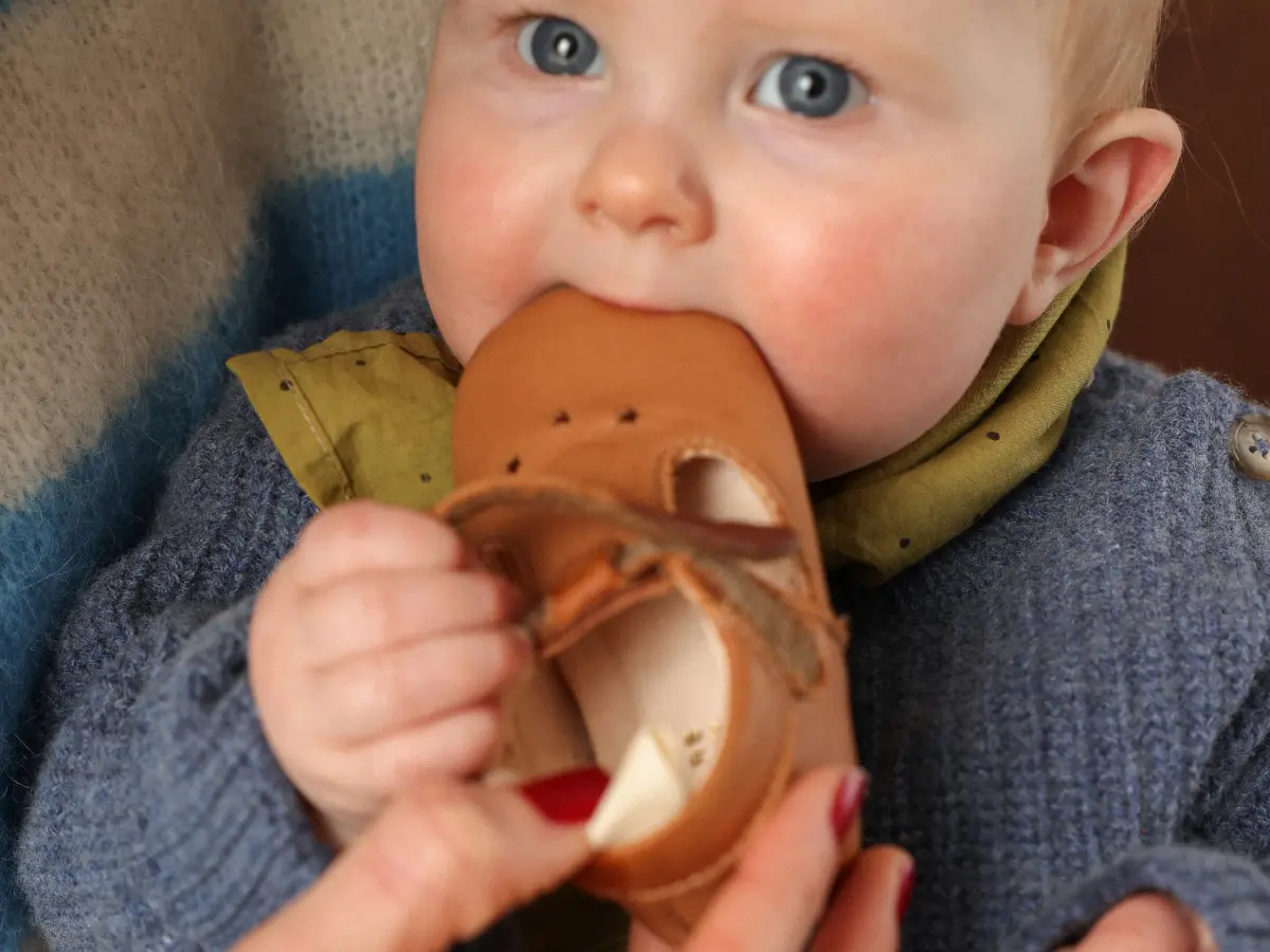 B&eacute;b&eacute; portant des chaussons premiers pas en cuir souple Lazare
