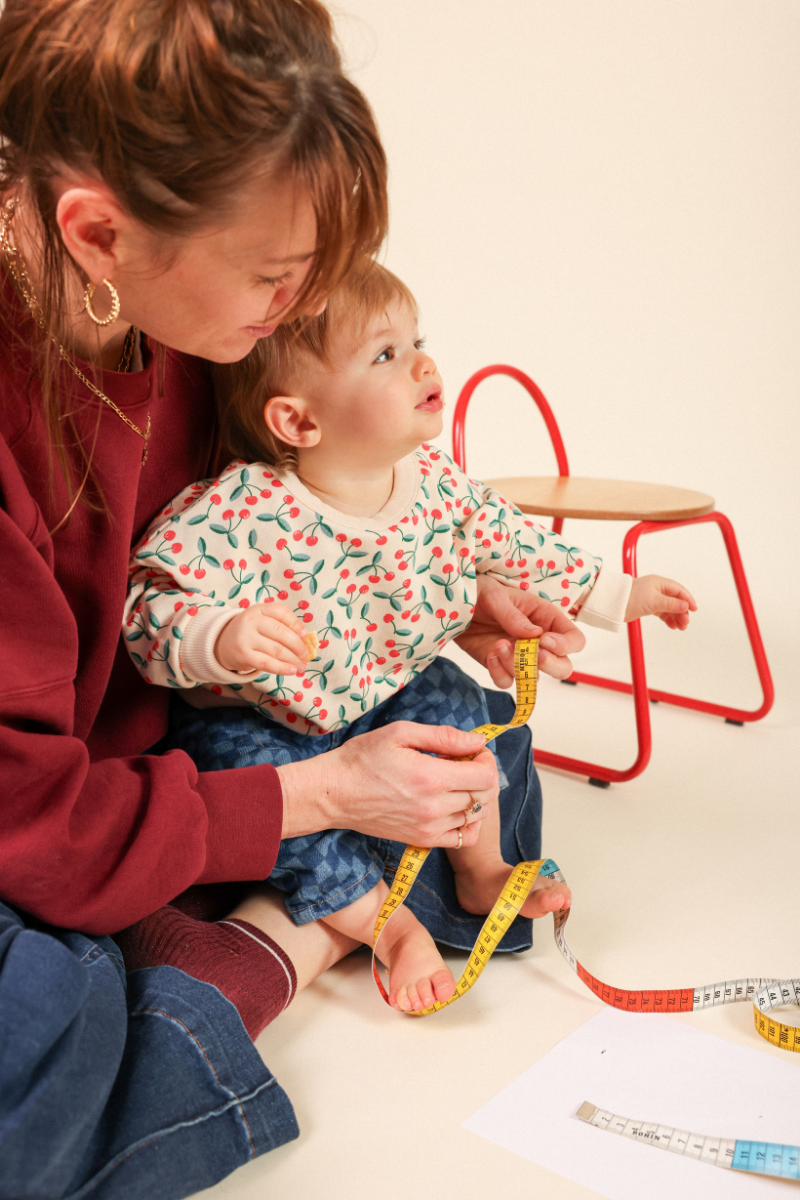Mesure du pied d'un bébé avec un guide de pointure, pour choisir la bonne taille