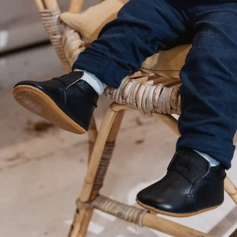 enfant portant les chausson alfred bleu marine en ayant les pieds dans le vide