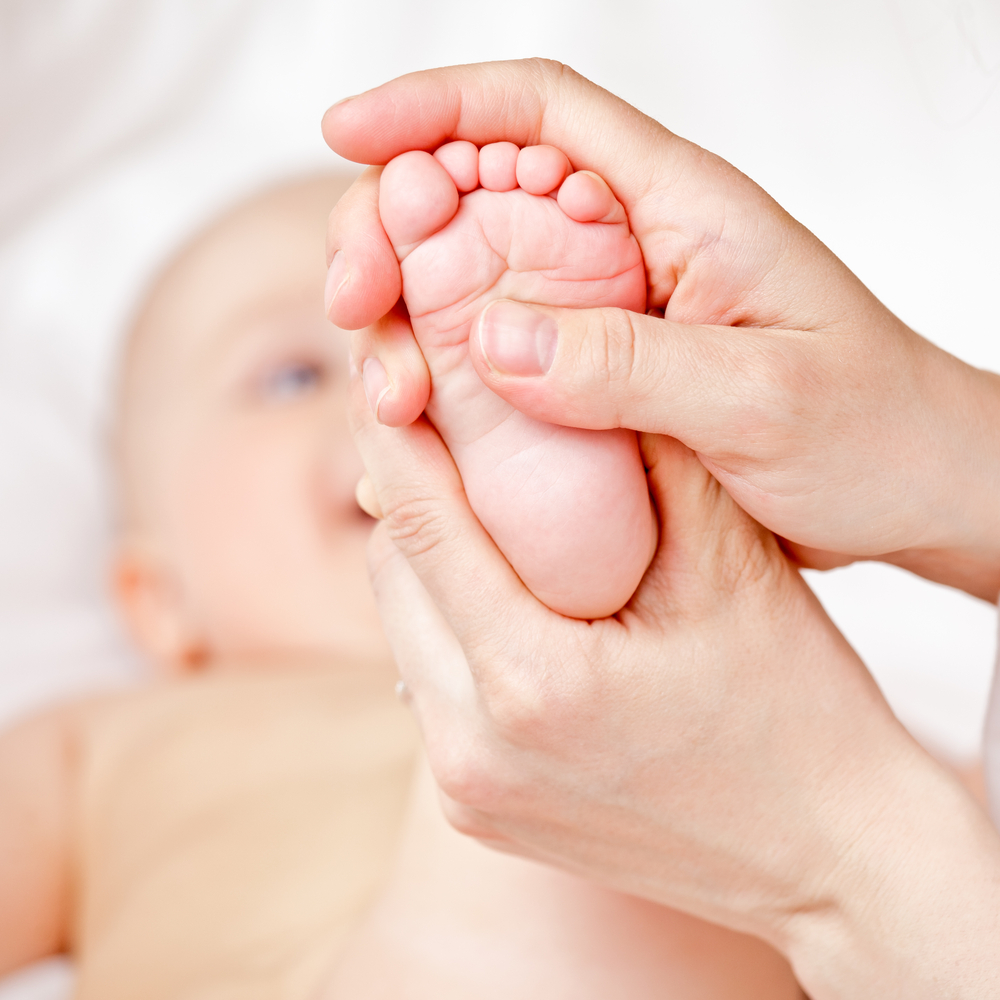 bébé qui se fait masser les pieds