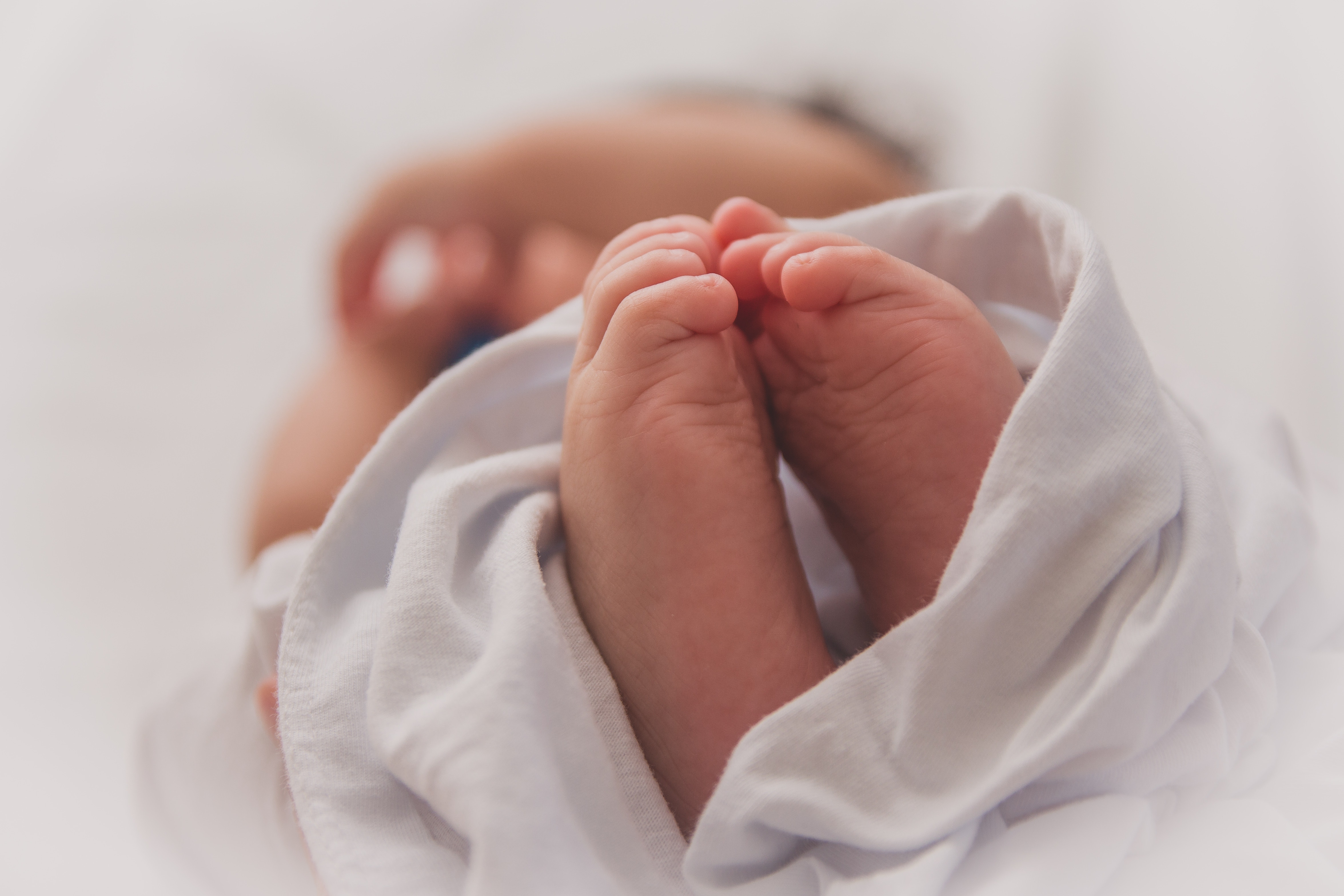 pieds d'un bebe dans un drap blanc