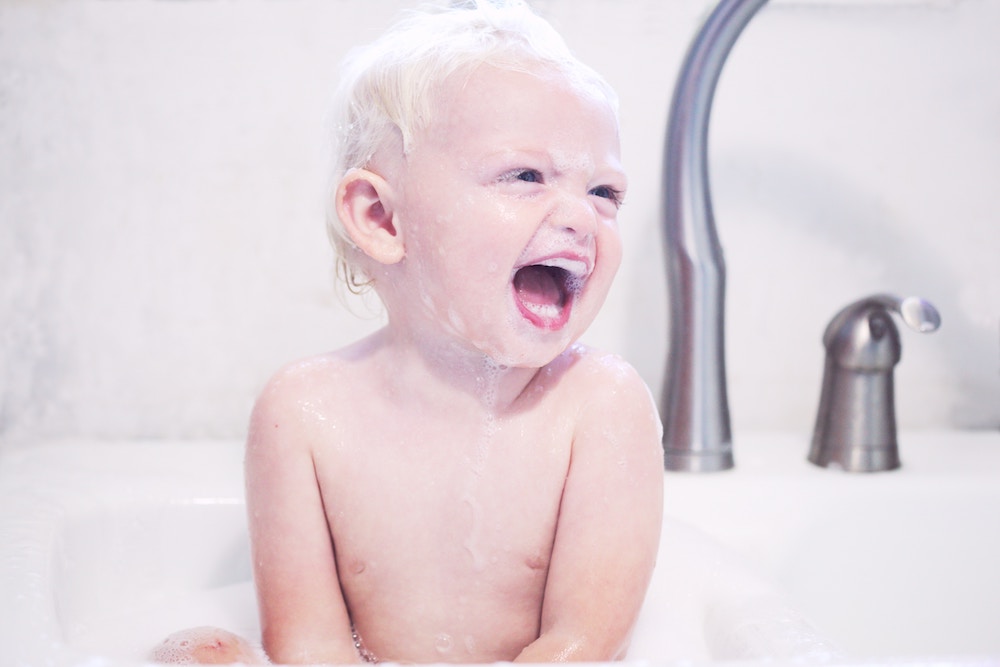bebe entrain de prendre un bain et rigole