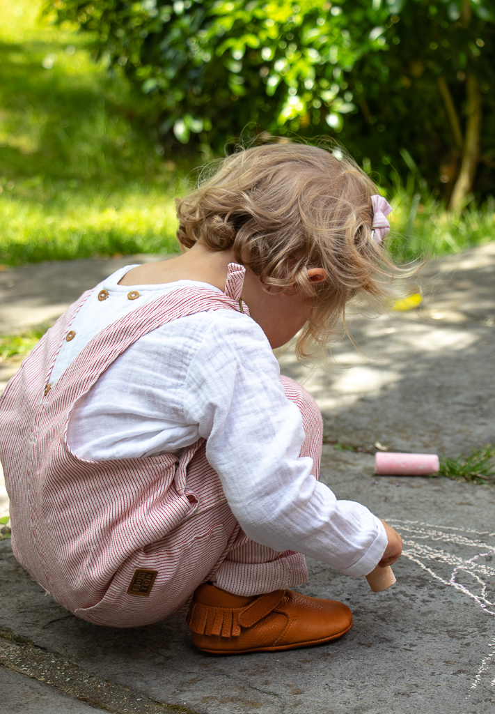 fille bebe qui joue dehors avec des chaussons en cuir souple couleur camel à tannage végétal