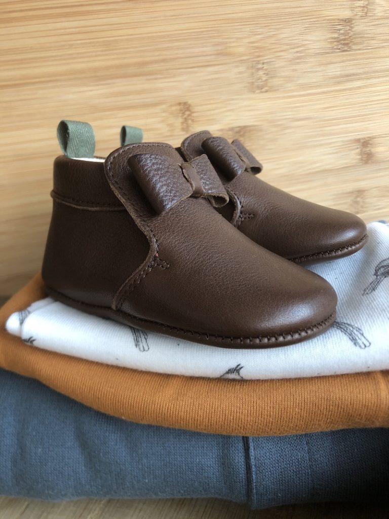 cuir en cuir marron avec un noeud sur une pile de vêtements