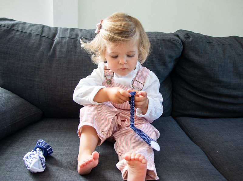 petite fille en train d'enfiler une paire de chaussettes