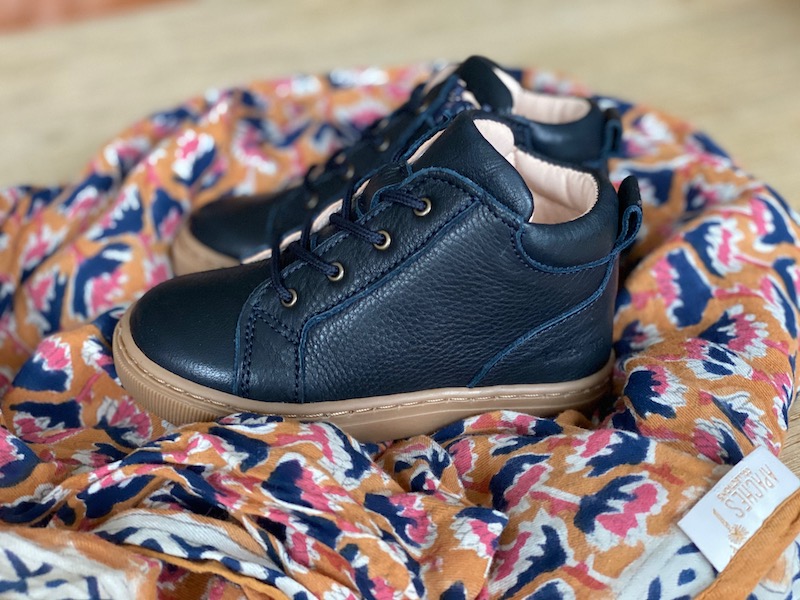 chaussures premiers pas Auguste bleu marine en cuir souple et lacets sur un foulard