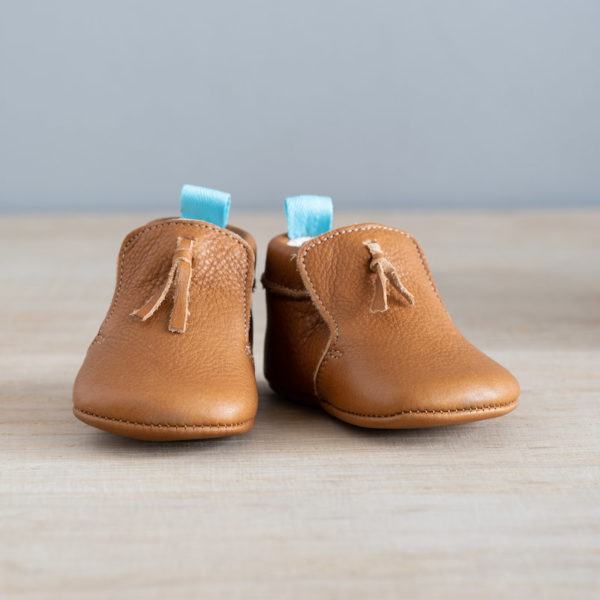 chaussons bébé en cuir souple marron Madeleine avec pompon sur le dessus vu face