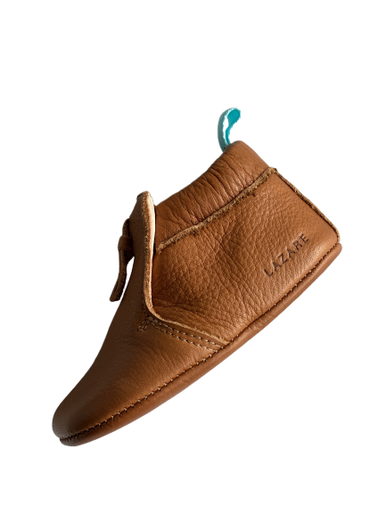 chaussons bébé en cuir souple marron Madeleine avec pompon sur le dessus vu de coté